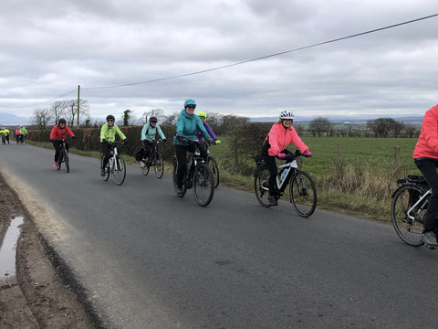 Women cyclists on country road